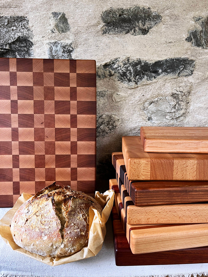 Wooden cutting boards with a loaf of bread on a stone surface