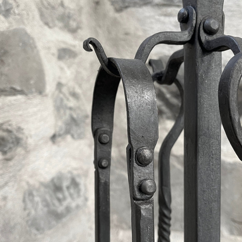 Close-up of a set of forged fire tools on a stone background