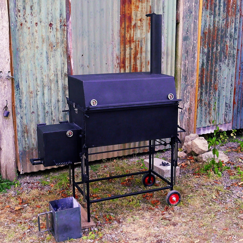Black barbecue grill with smoker attachment against a rustic metal wall.