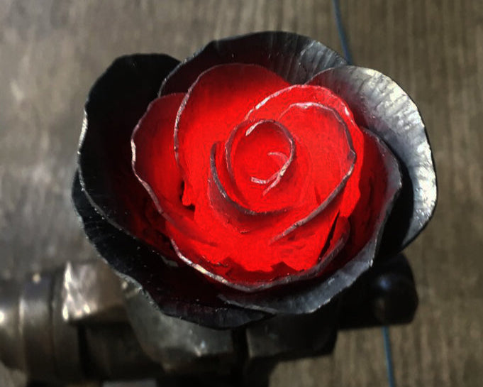 Forged rose with red center on a dark background